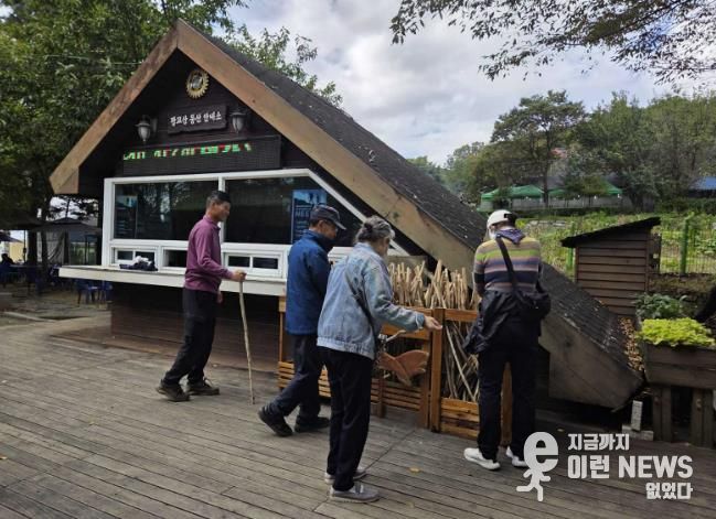등산객들이 광교산 등산 안내소 앞에 있는 지팡이를 고르고 있다.