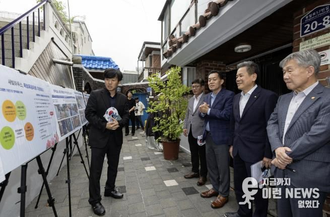 수원시와 한국보훈복지의료공단이 수원지역 독립유공자 후손의 집수리를 지원한 새빛하우스 앞에서 관계자들이 사업 설명을 듣고 있다.